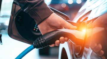 mano conectando cargador de vehículo eléctrico
