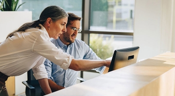 hombre y mujer viendo una computadora