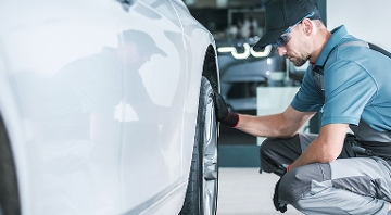 hombre a lado de llanta de coche revisando