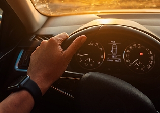 Mano de una persona sujeanto el volante de un coche