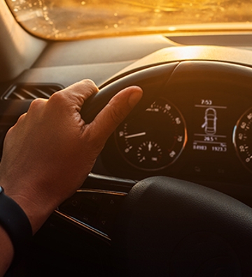 Mano de una persona sujeanto el volante de un coche