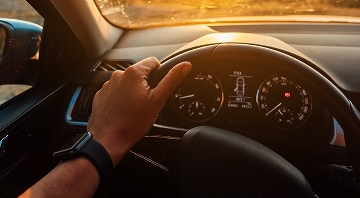 Mano de una persona sujeanto el volante de un coche