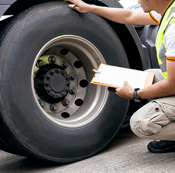 Técnico de mantenimiento inspeccionando un neumático