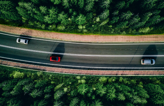 Autos en carretera con áreas verdes