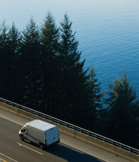 camioneta en carretera a lado de lago