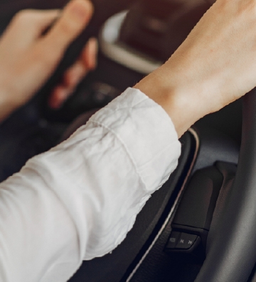 dos manos de mujer en volante de coche