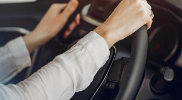dos manos de mujer en volante de coche